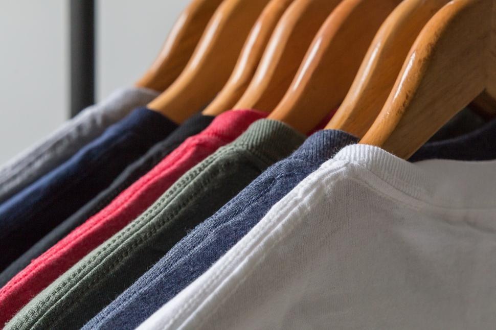 Assorted shirts hanging on wooden hangers